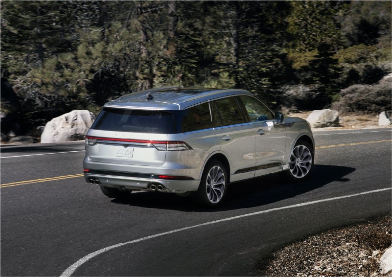 A 2023 Lincoln Aviator® Grand Touring model is shown being driven on a tight turn of a mountain road | Dave Sinclair Lincoln in St Louis MO